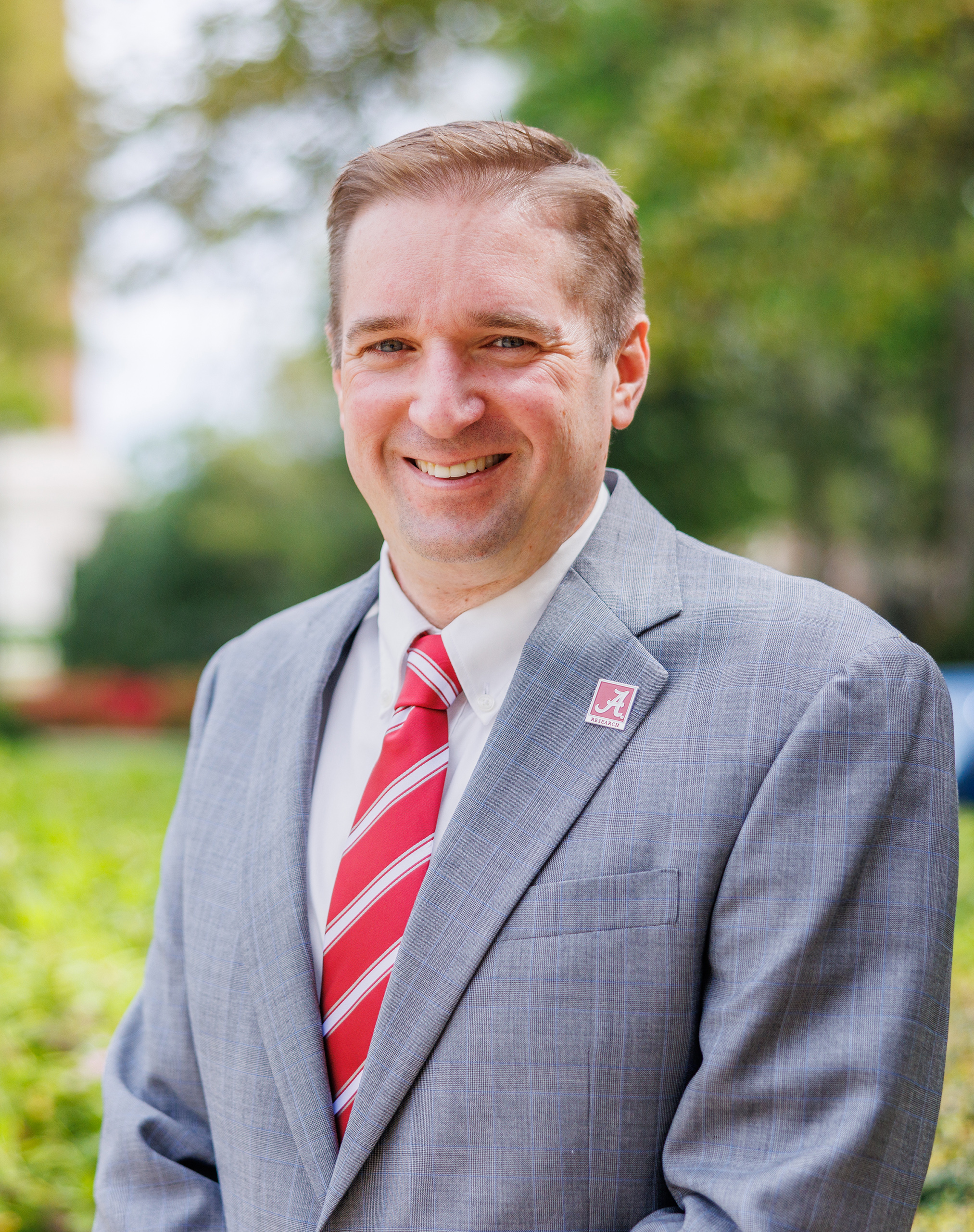 A white male poses for a photo outdoors