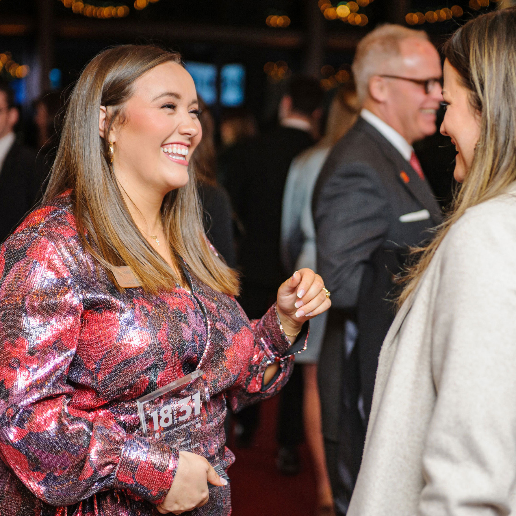 A white woman smiles while talking to another white woman