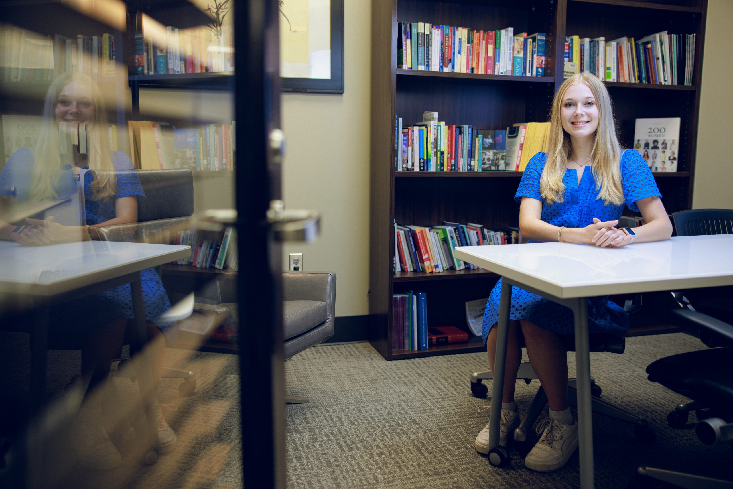 A white female college student sits at a table